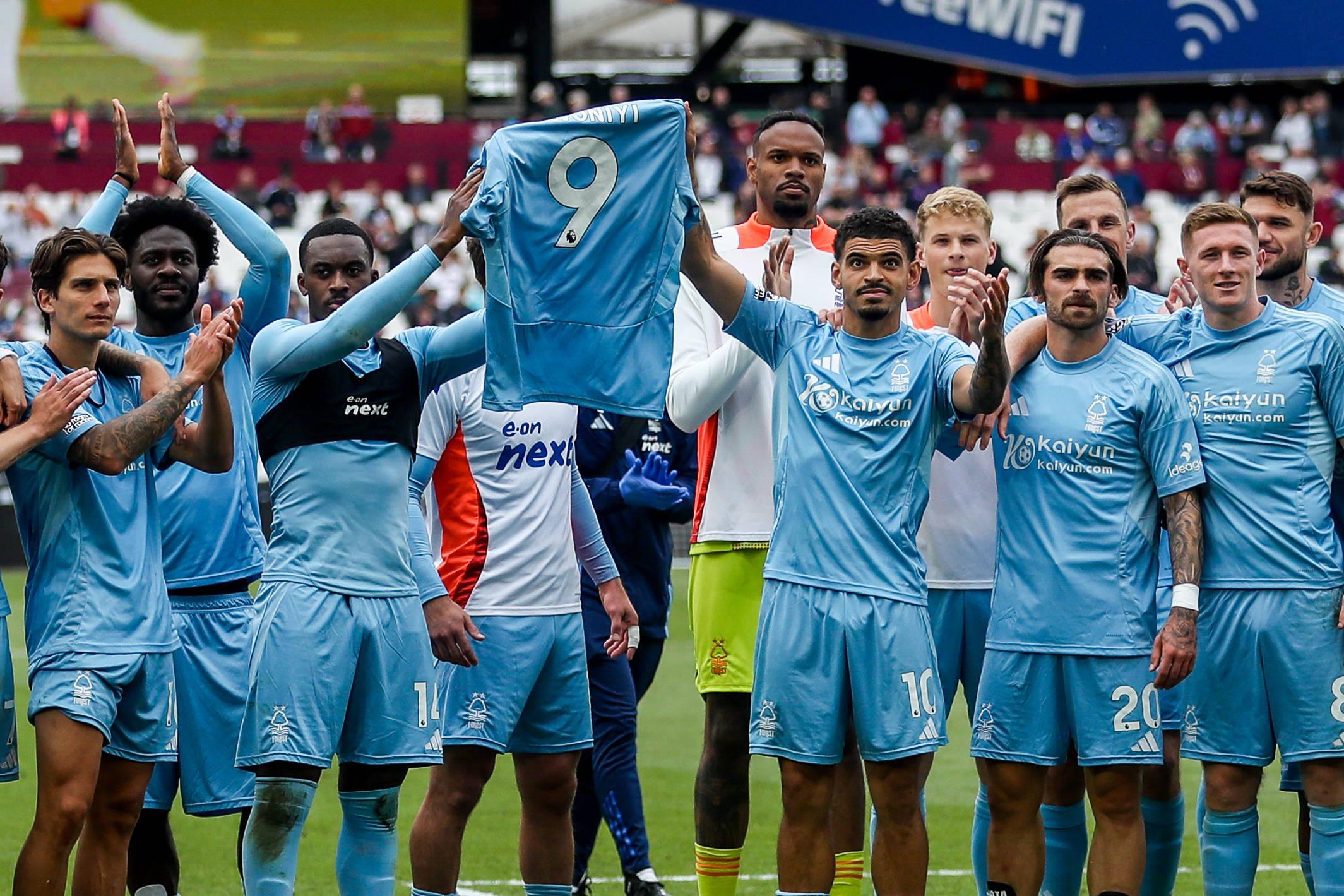 Nottingham Forest players hold up Taiwo Awoniyis shirt in support