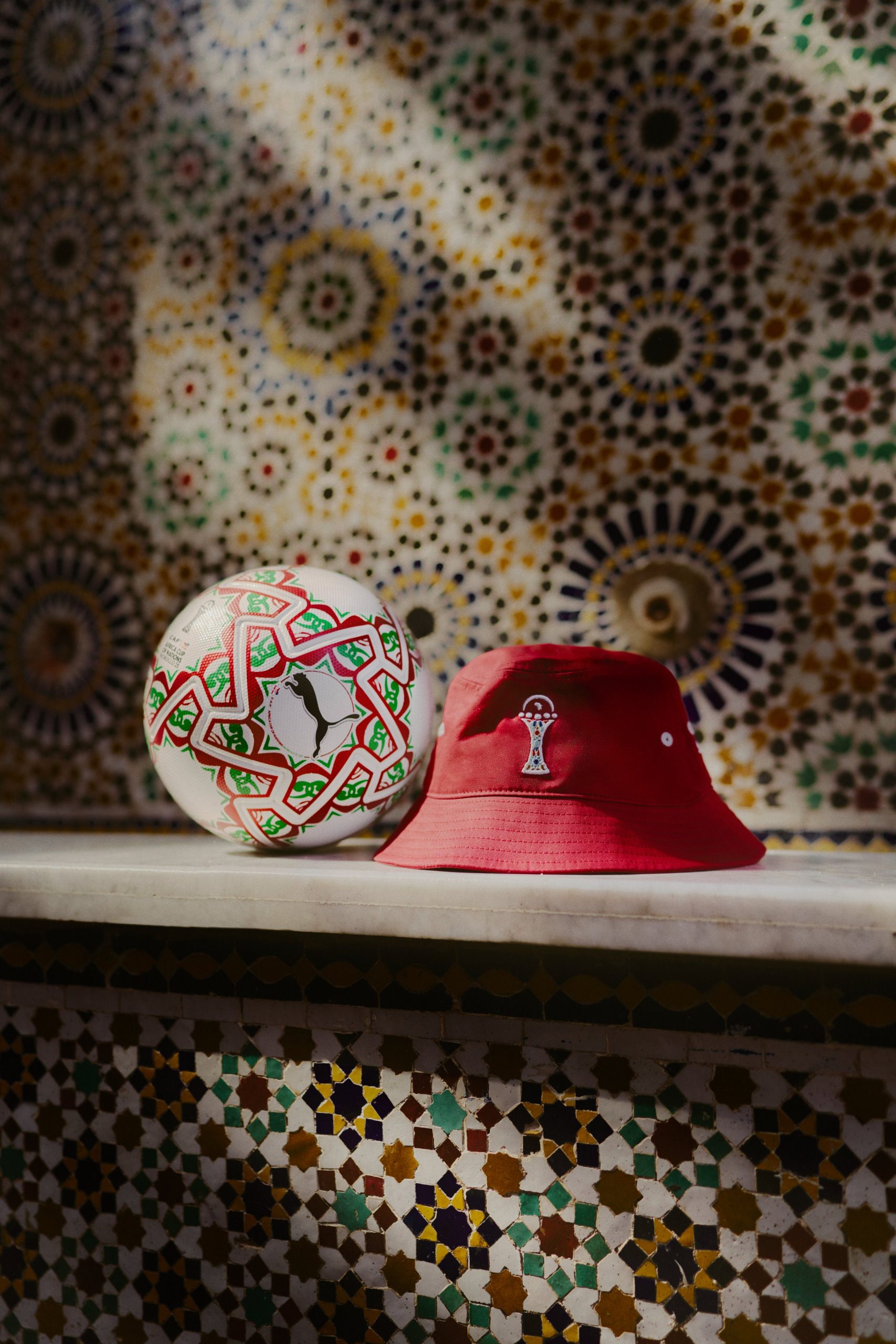 The AFCON 2025 official match ball poses with a cap