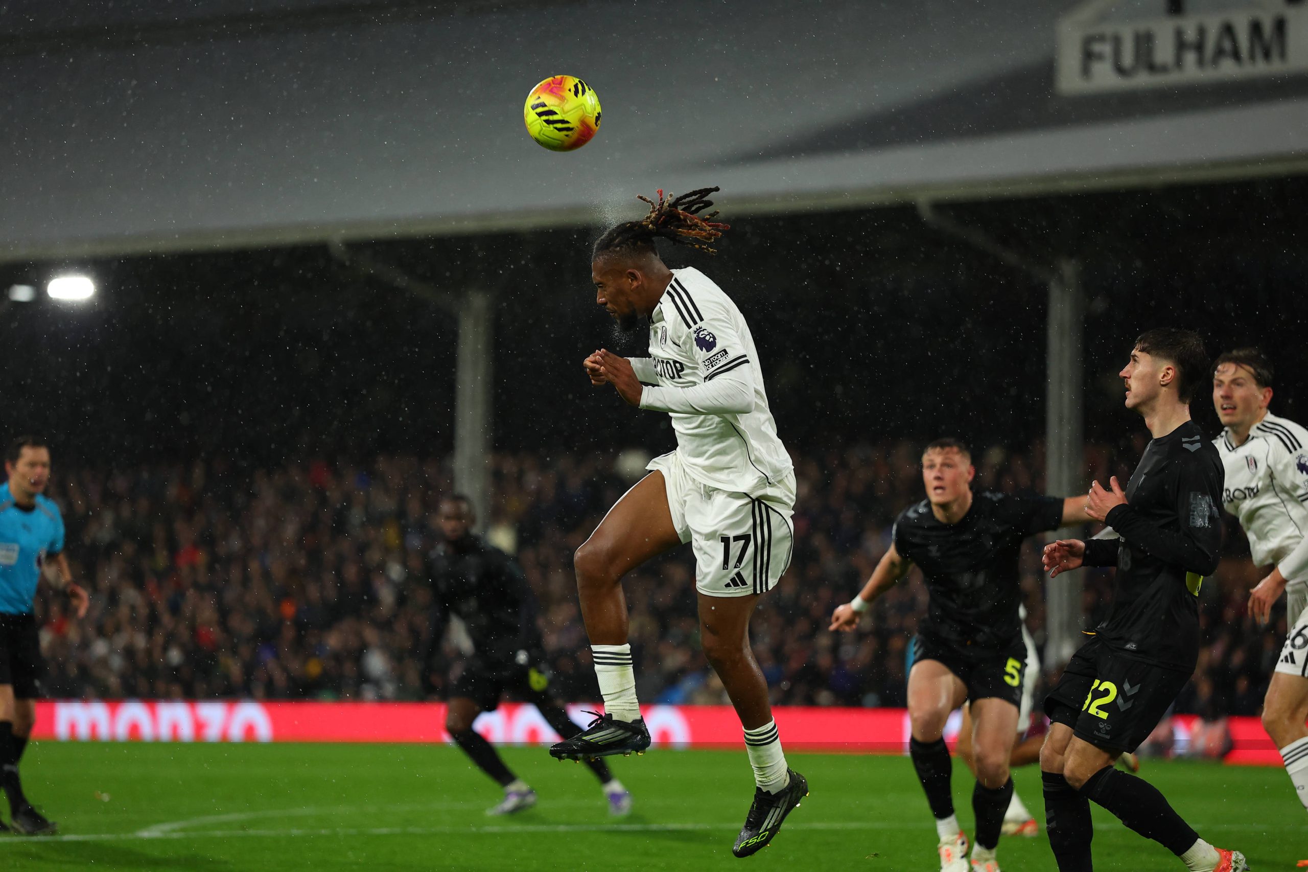 Alex Iwobi heads the ball out into midfield