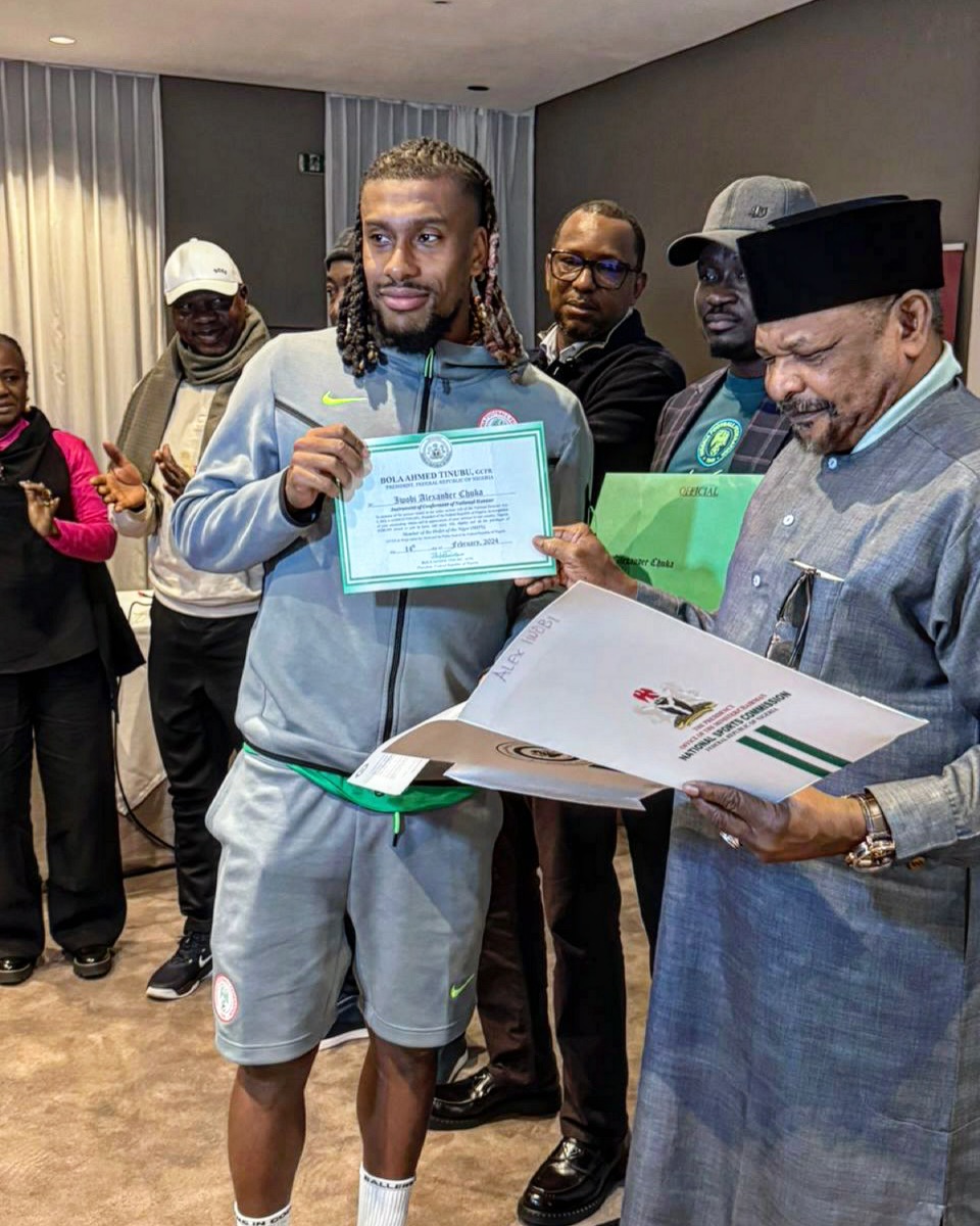 Super Eagles star Alex Iwobi receiving the document to his property