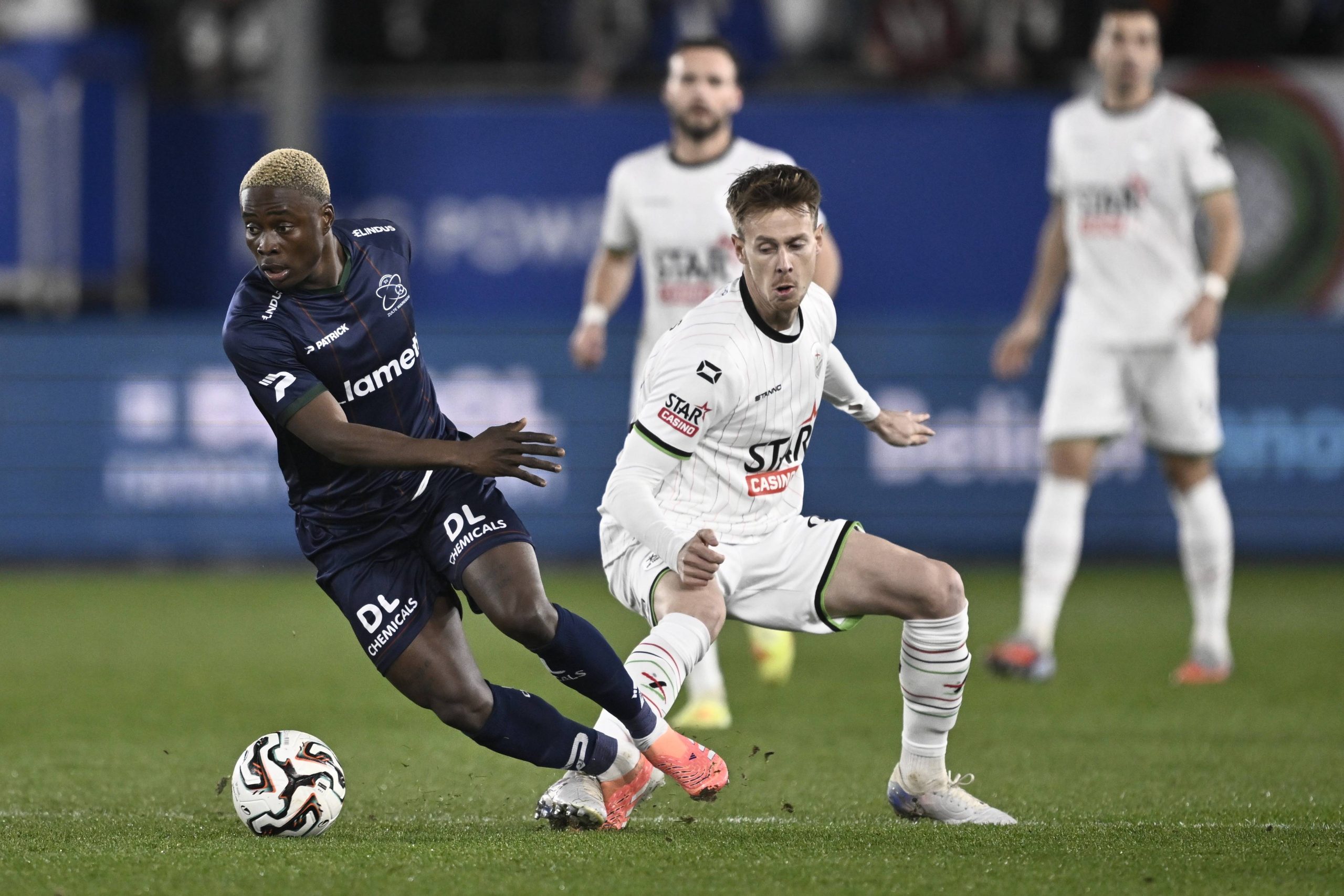 Tochukwu Nnadi and Mathieu Maertens fight for the ball during a soccer match between Oud-Heverlee Leuven and Zulte Waregem