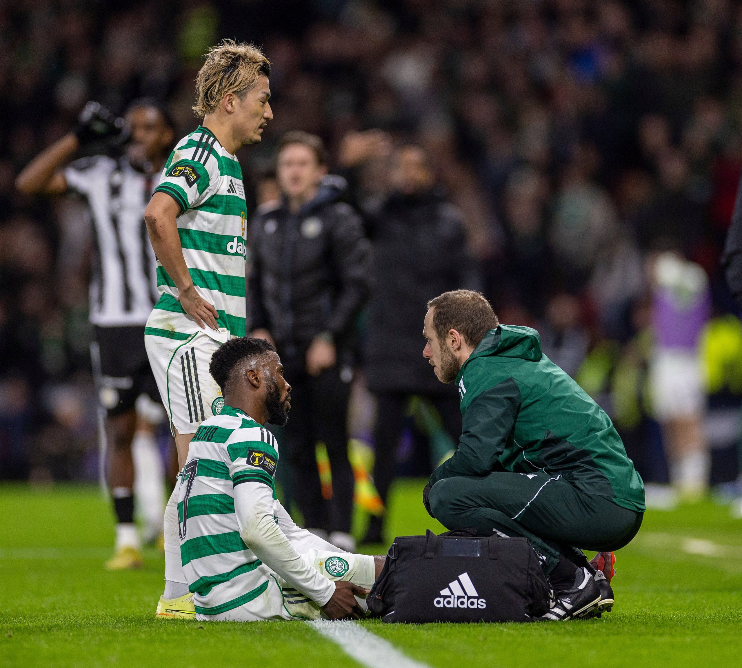 Kelechi Iheanacho of Celtic feels his hamstring as the medical team check him over