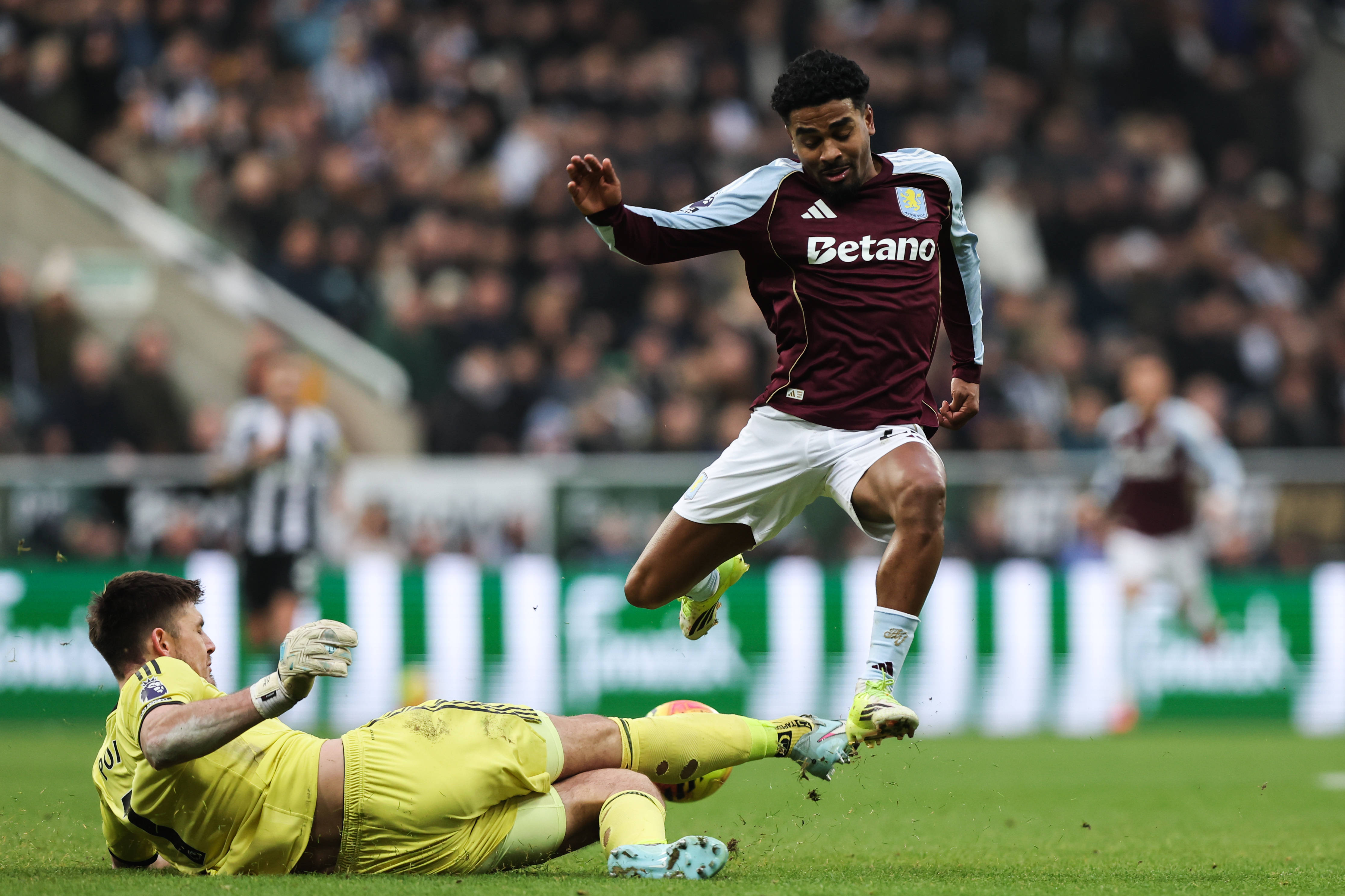 Nick Pope tackles Ian Maatsen during the Newcastle United vs Aston Villa Premier League match