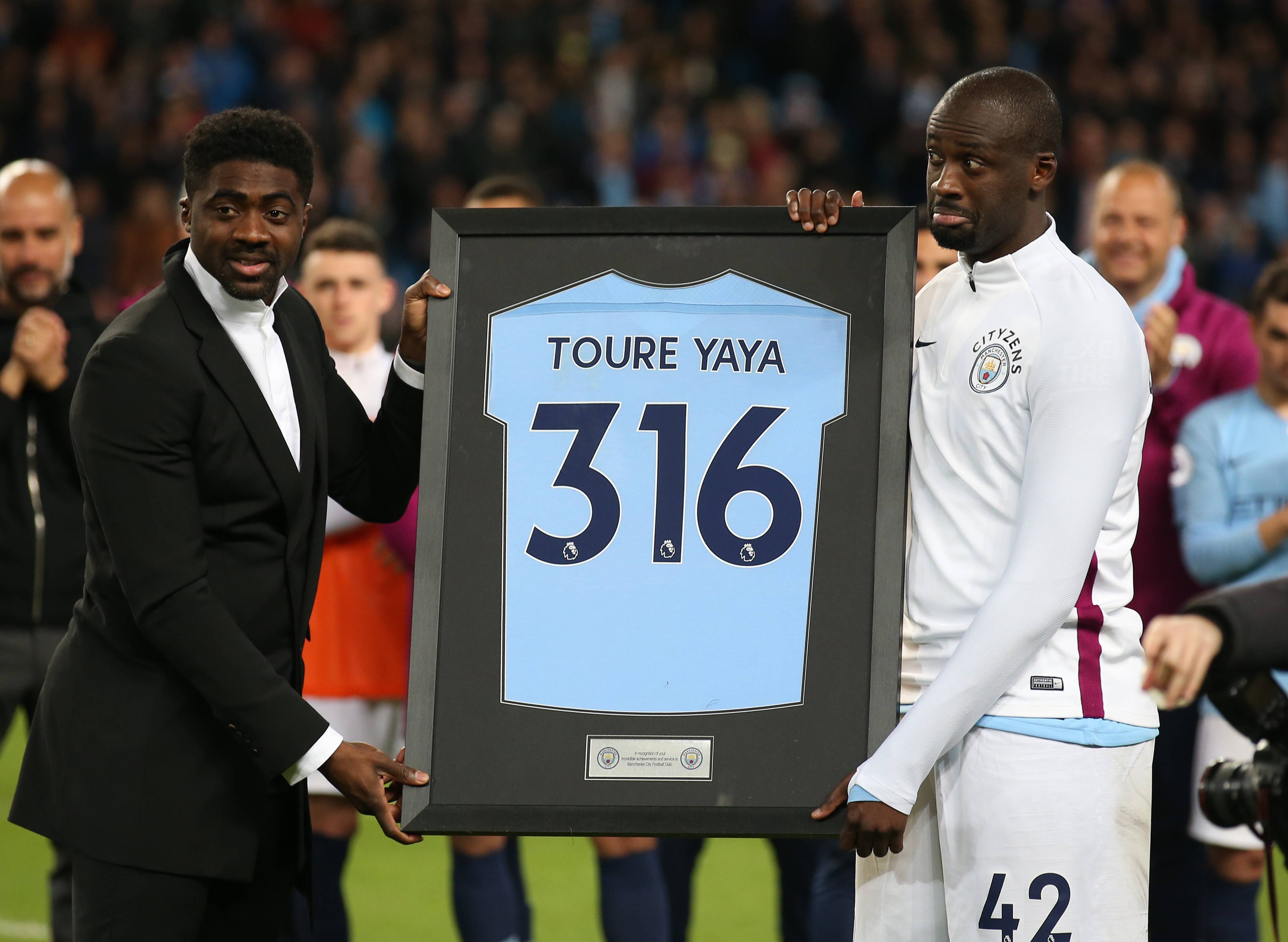  Kolo Toure presents his brother Yaya Toure of Manchester City with a framed shirt during the premier league match at the Etihad Stadium