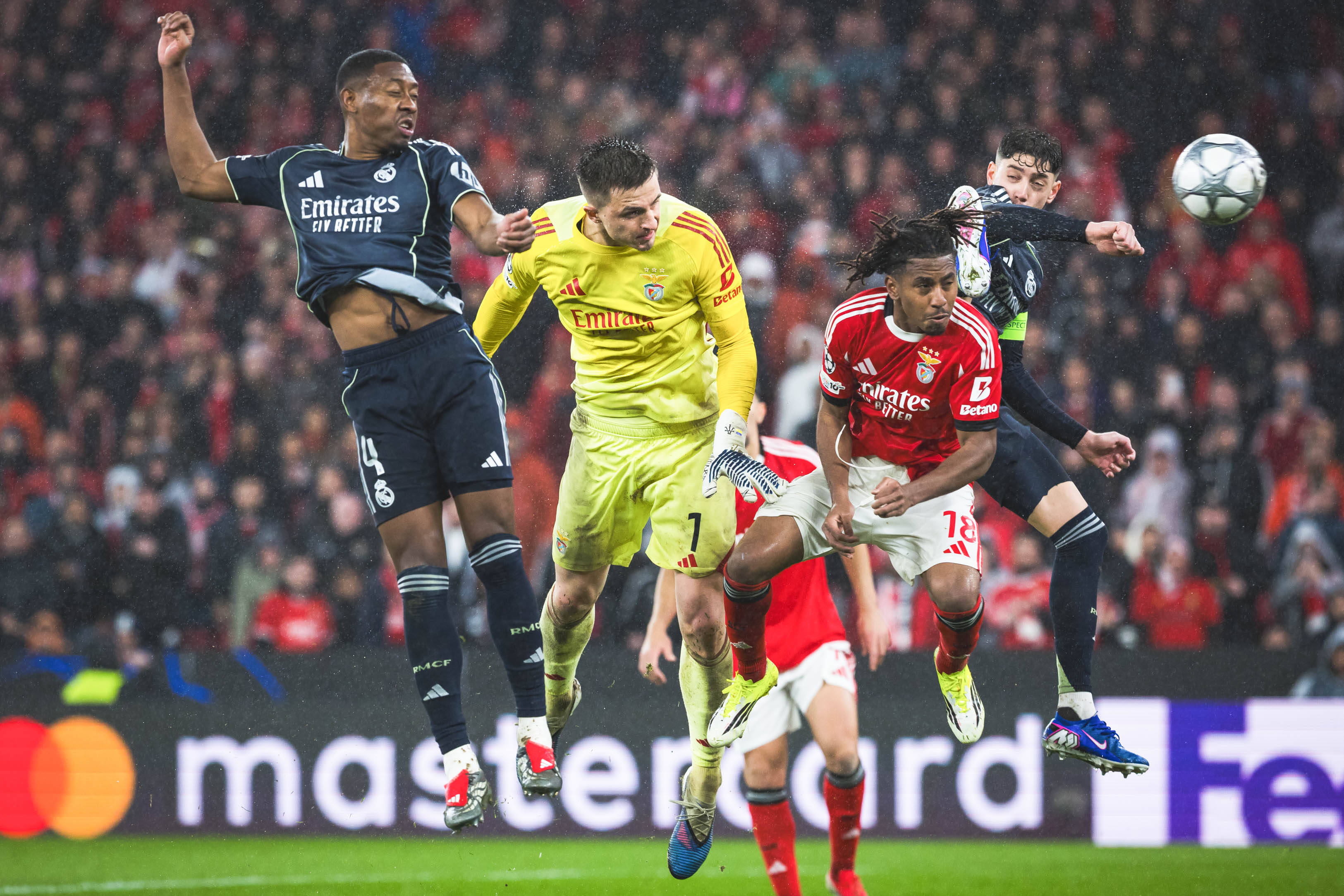 Anatoliy Trubin of SL Benfica heads LC towards the goal, between players David Alaba of Real Madrid CF