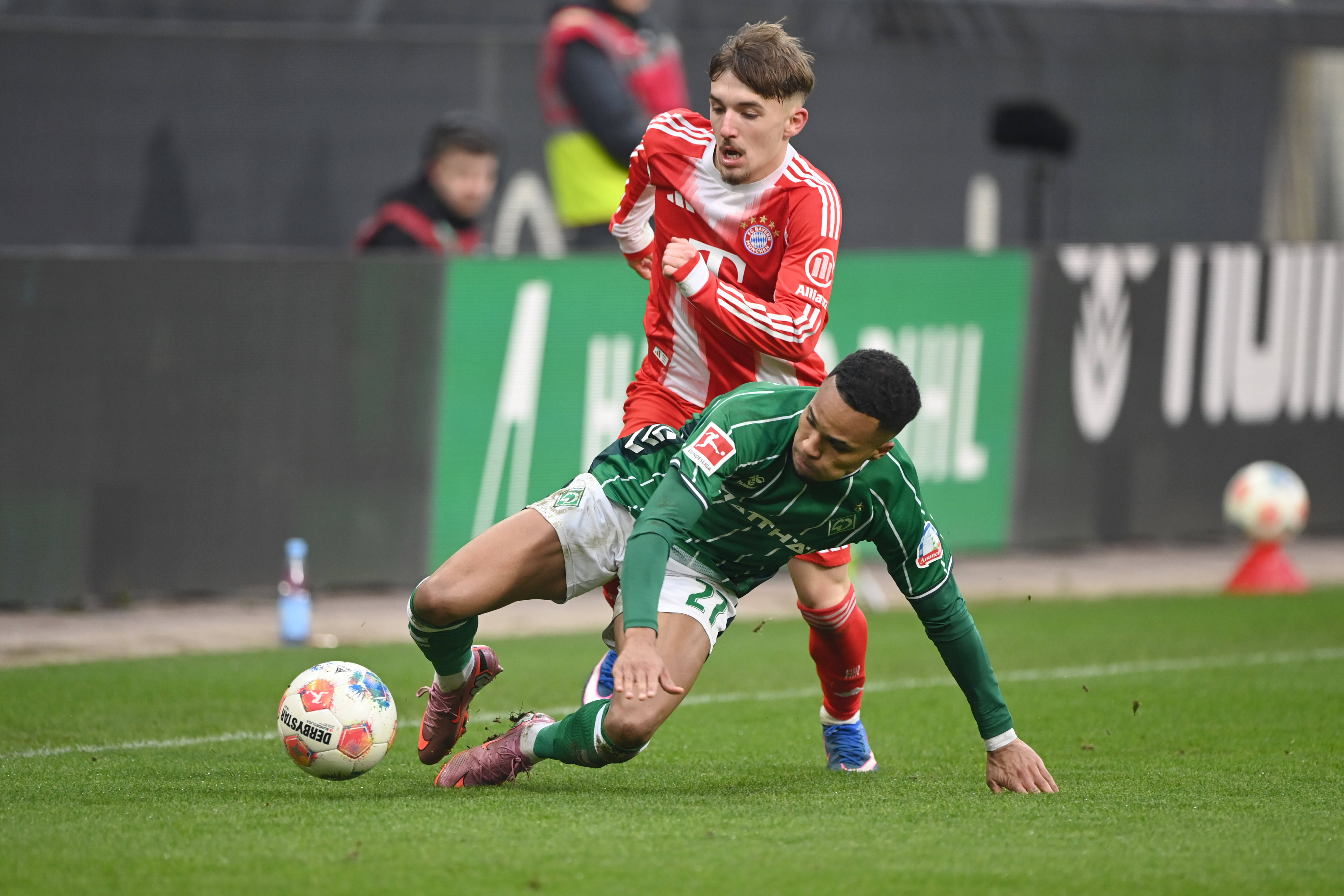 Felix Agu battles for the ball with Lennart Karl in Werder Bremen's loss to Bayern Munich
