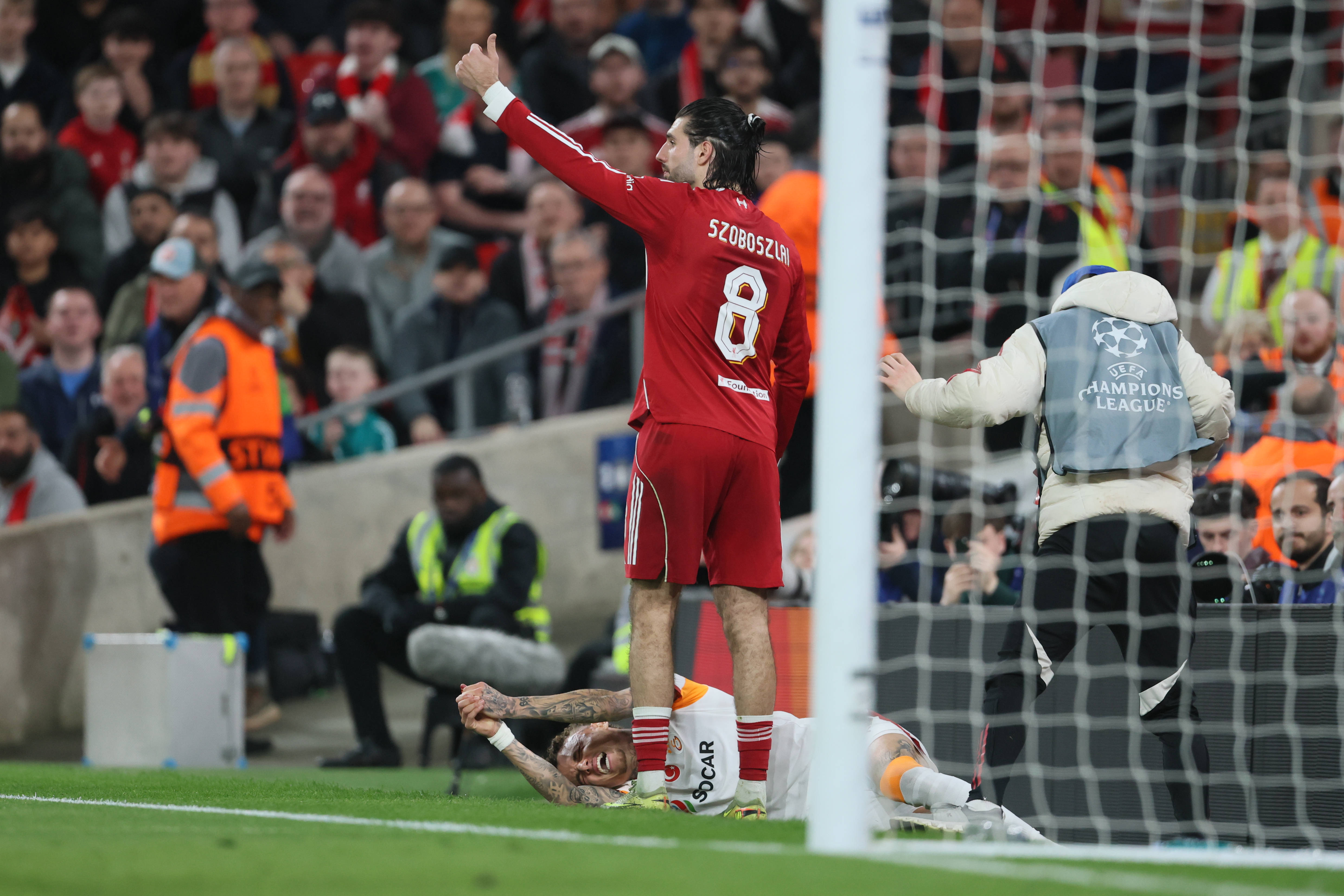 Dominik Szoboszlai of Liverpool calls for assistance as Noa Lang of Galatasaray A.S is injured
